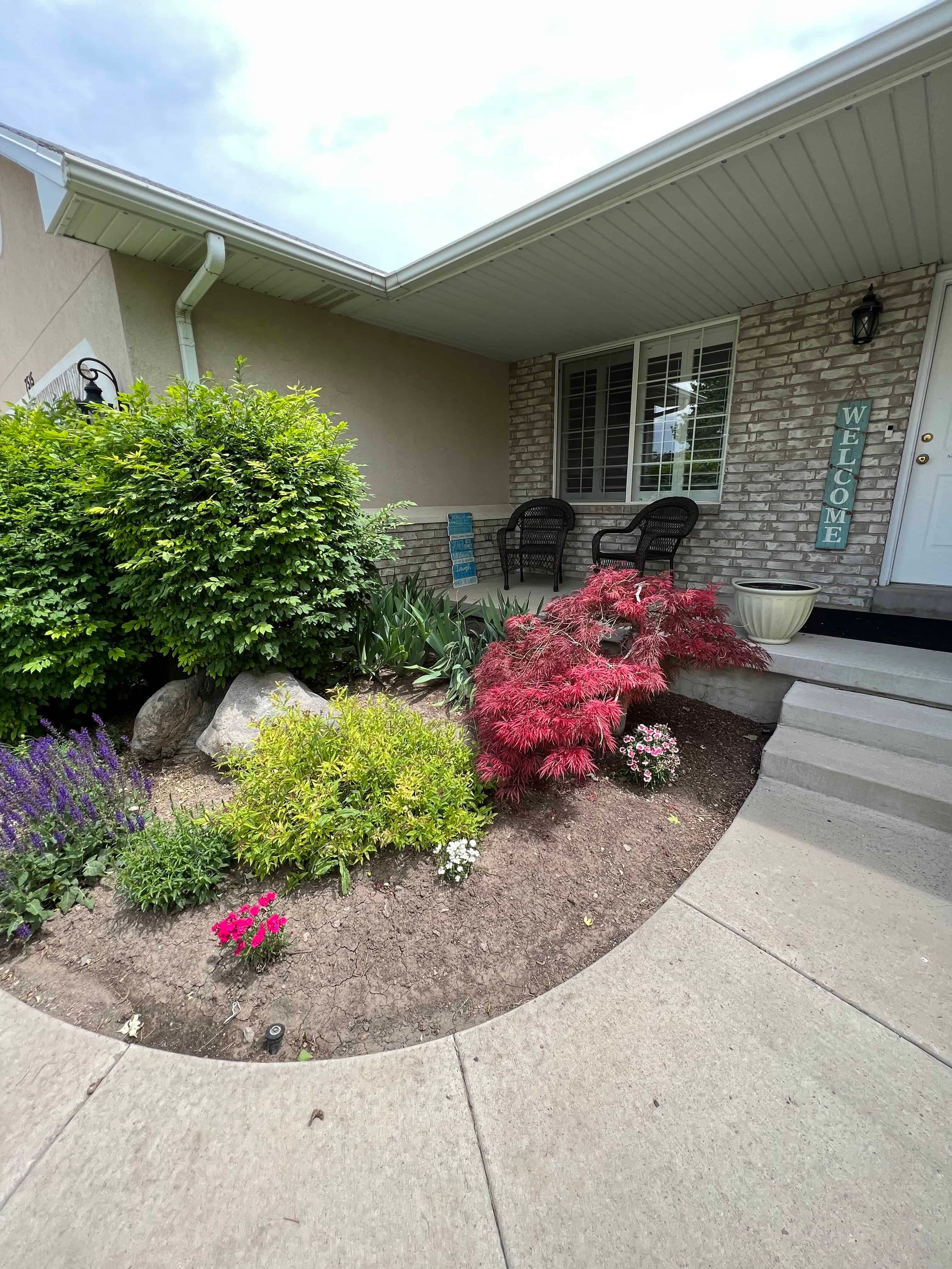 Colorful foundation planting bed beside a covered front entry