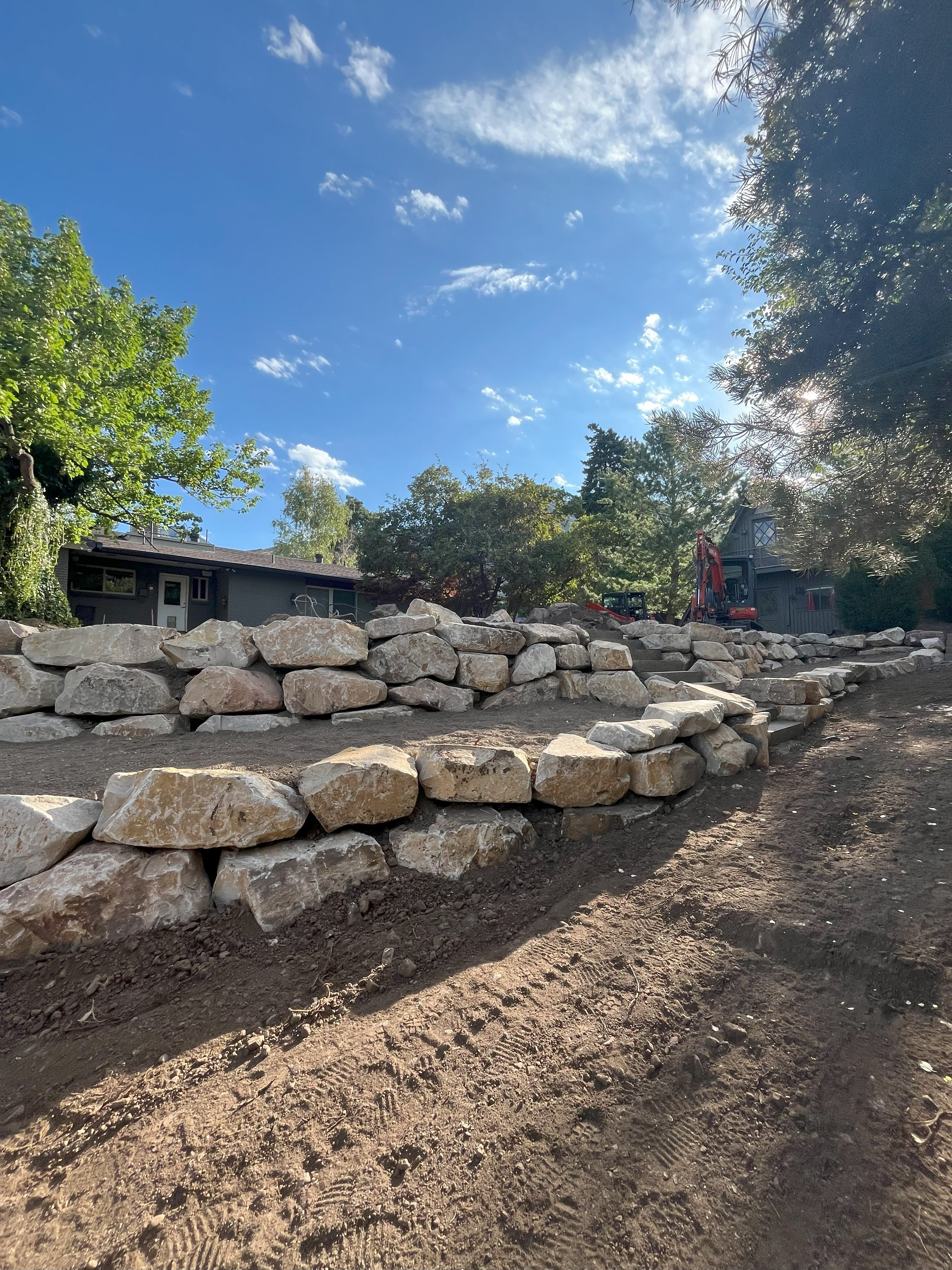 Boulder retaining wall installation in progress in Holladay, Utah.