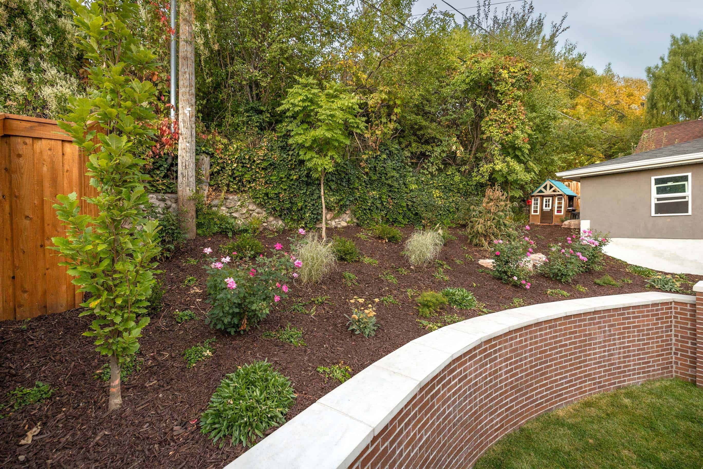 Upper section of a custom retaining wall holding back a hillside with a designed plant space in Federal Heights, Utah.