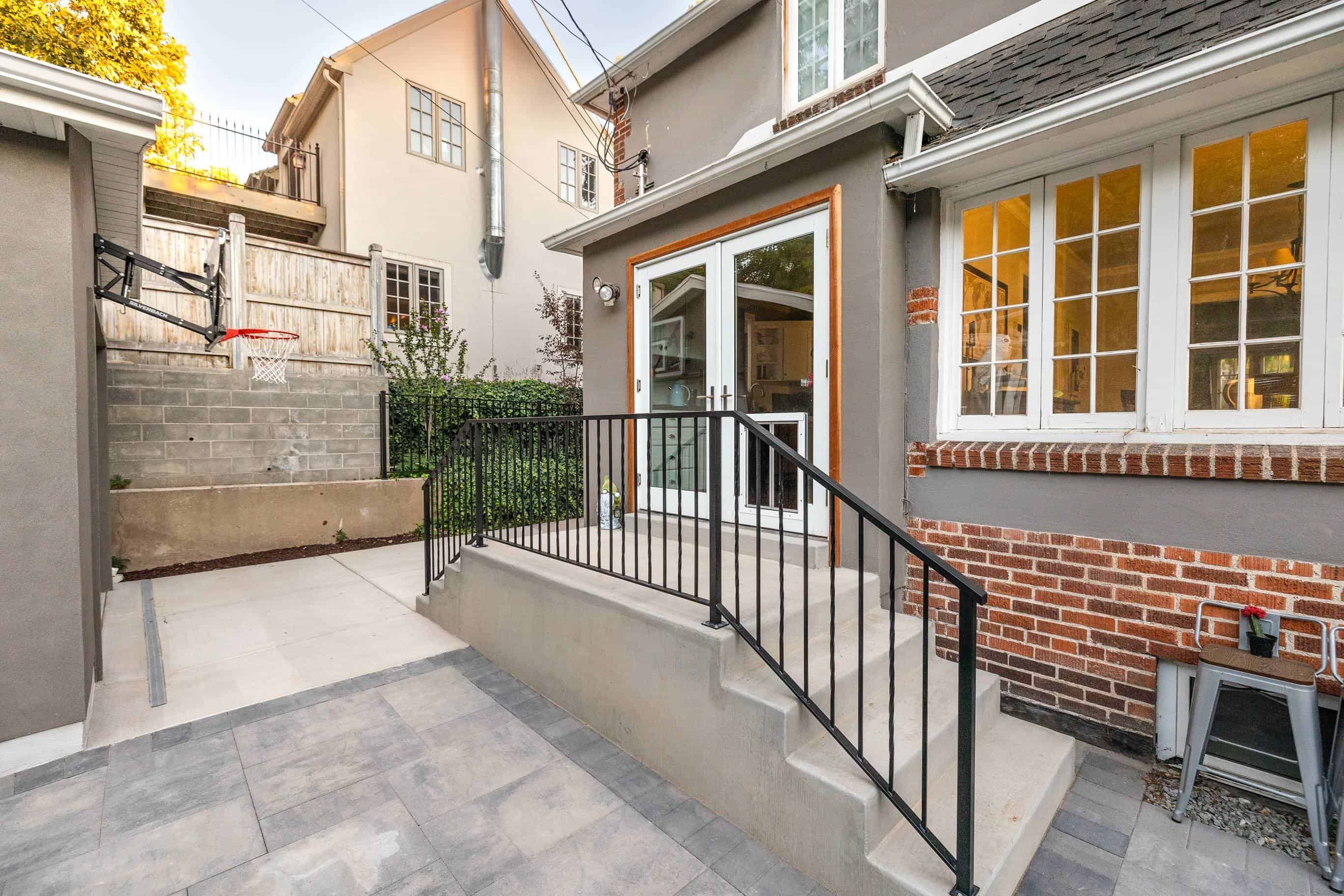 Concrete steps and pavers installation with black metal railing in Federal Heights, Utah.