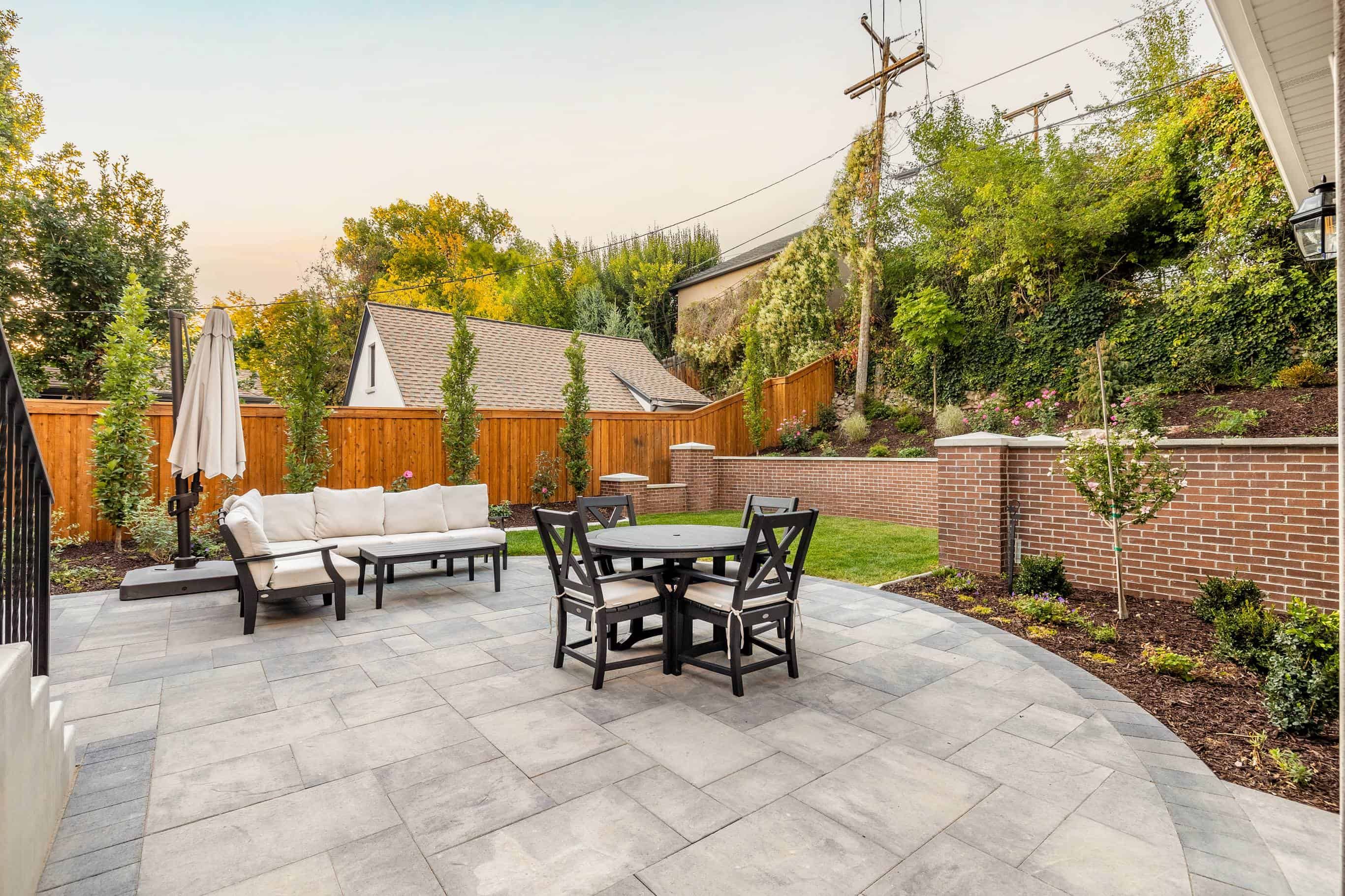 Gray pavers installation featuring outdoor furniture as part of a full landscape design in Federal Heights, Utah.