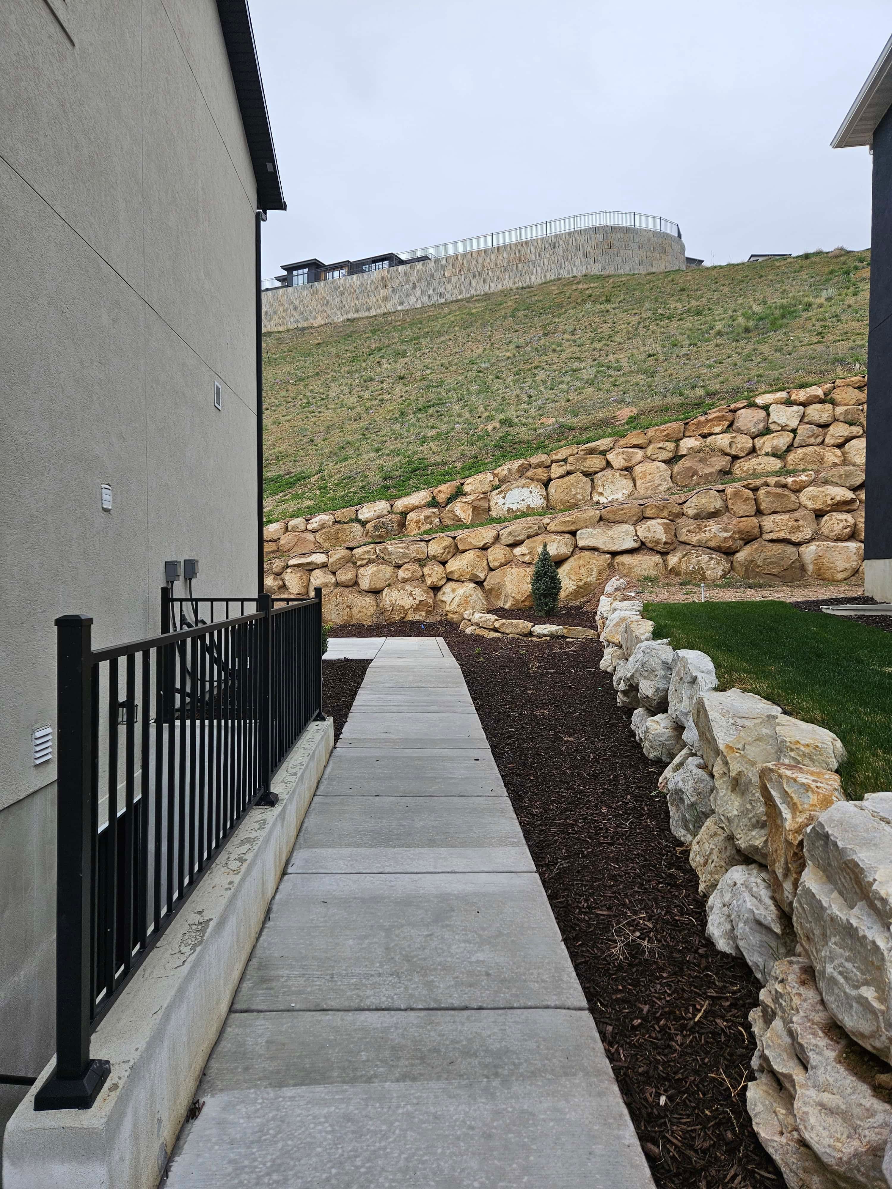 Concrete walkway leading to backyard in Lehi, Utah landscape installation.