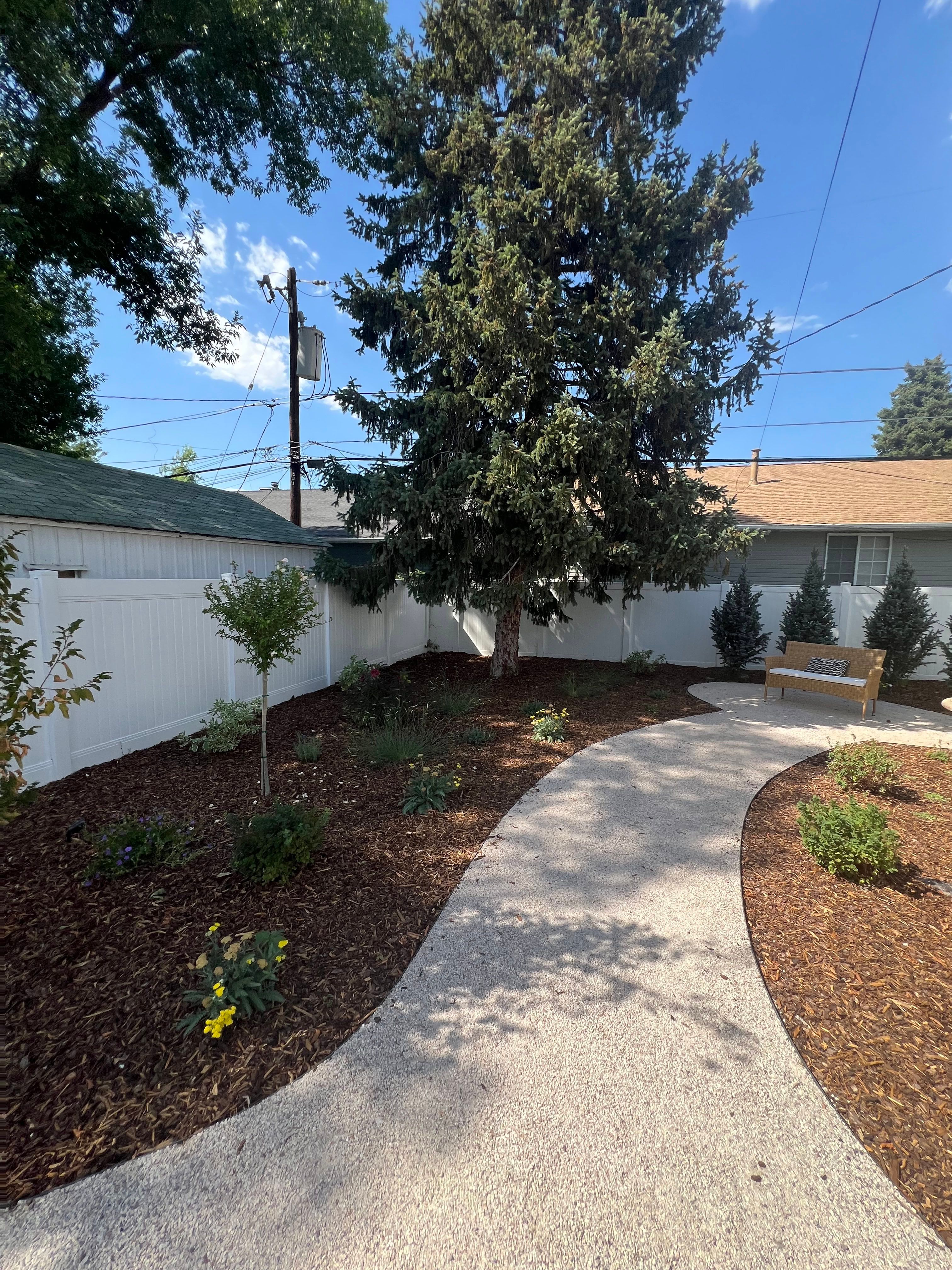 Millcreek xeriscape walkway from a new angle with bark mulch and drought-tolerant plants.