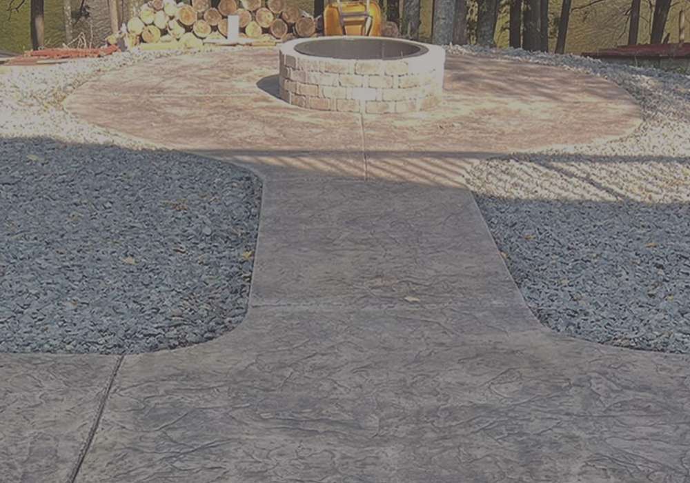 Tan concrete path with patio around a fire pit in Herriman, Utah., best concrete contractors