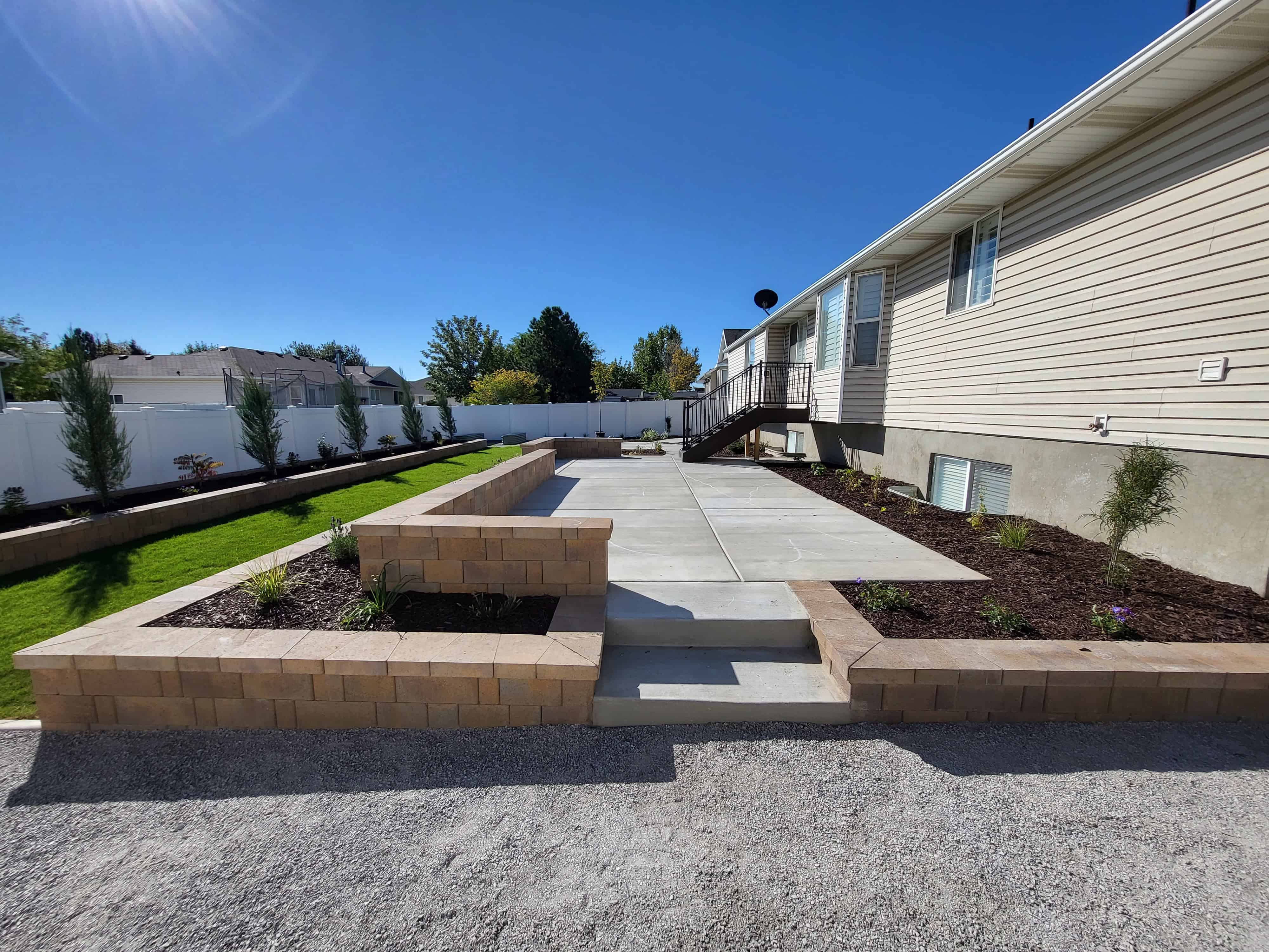 Tiered block retaining walls and paver patio in a completed backyard