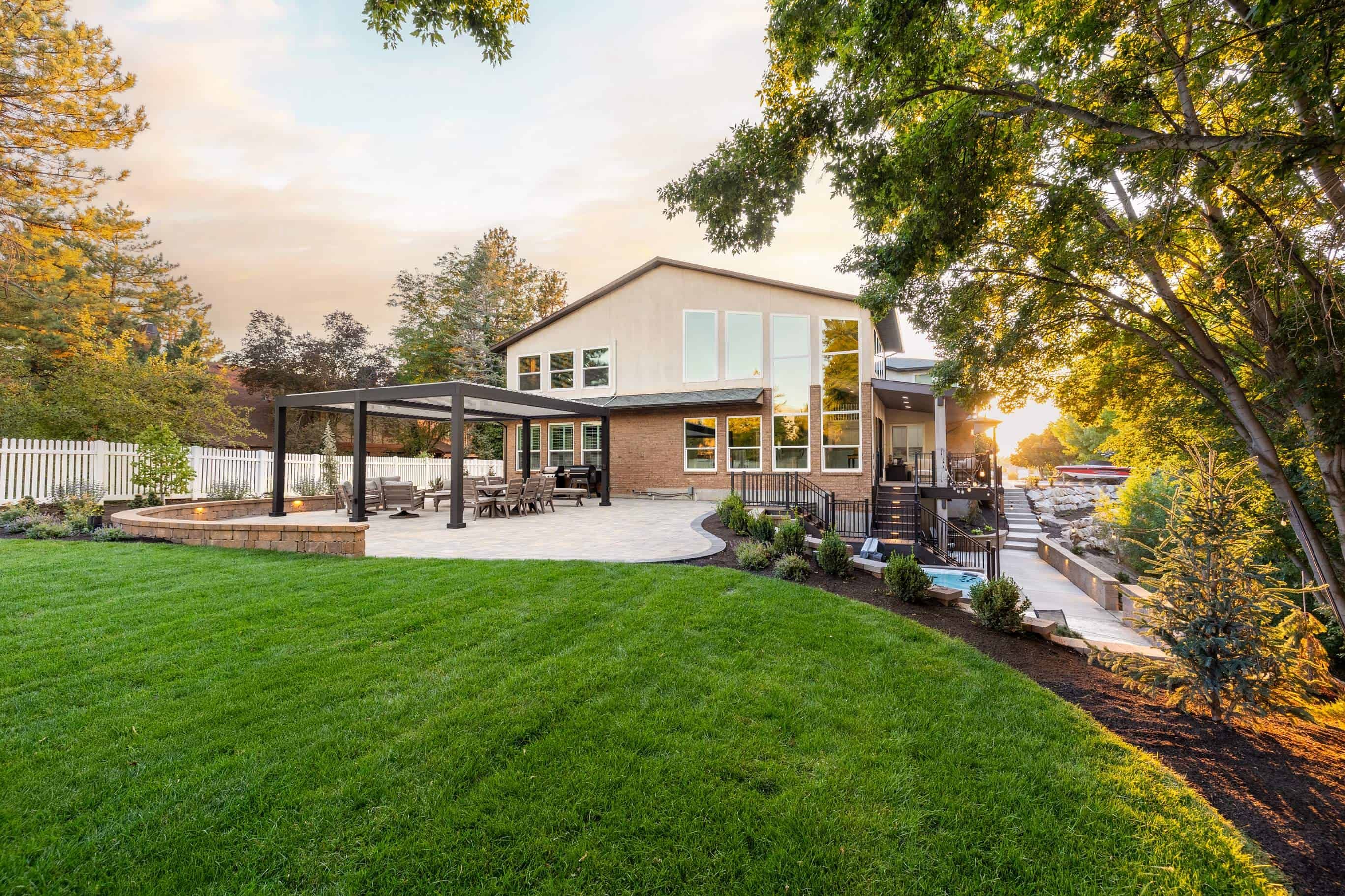 Backyard landscape design featuring pavers patio, shade covering, and custom concrete work in Murray, Utah., murray landscape service