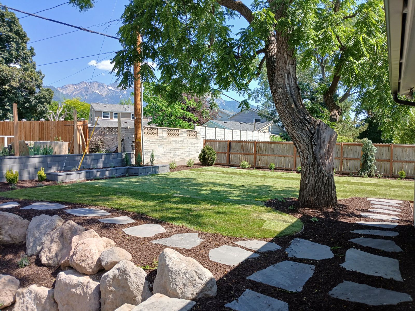 Millcreek Back yard remodel, cedar fence, Belgard Retaining wall, flagstone walk, sod.
