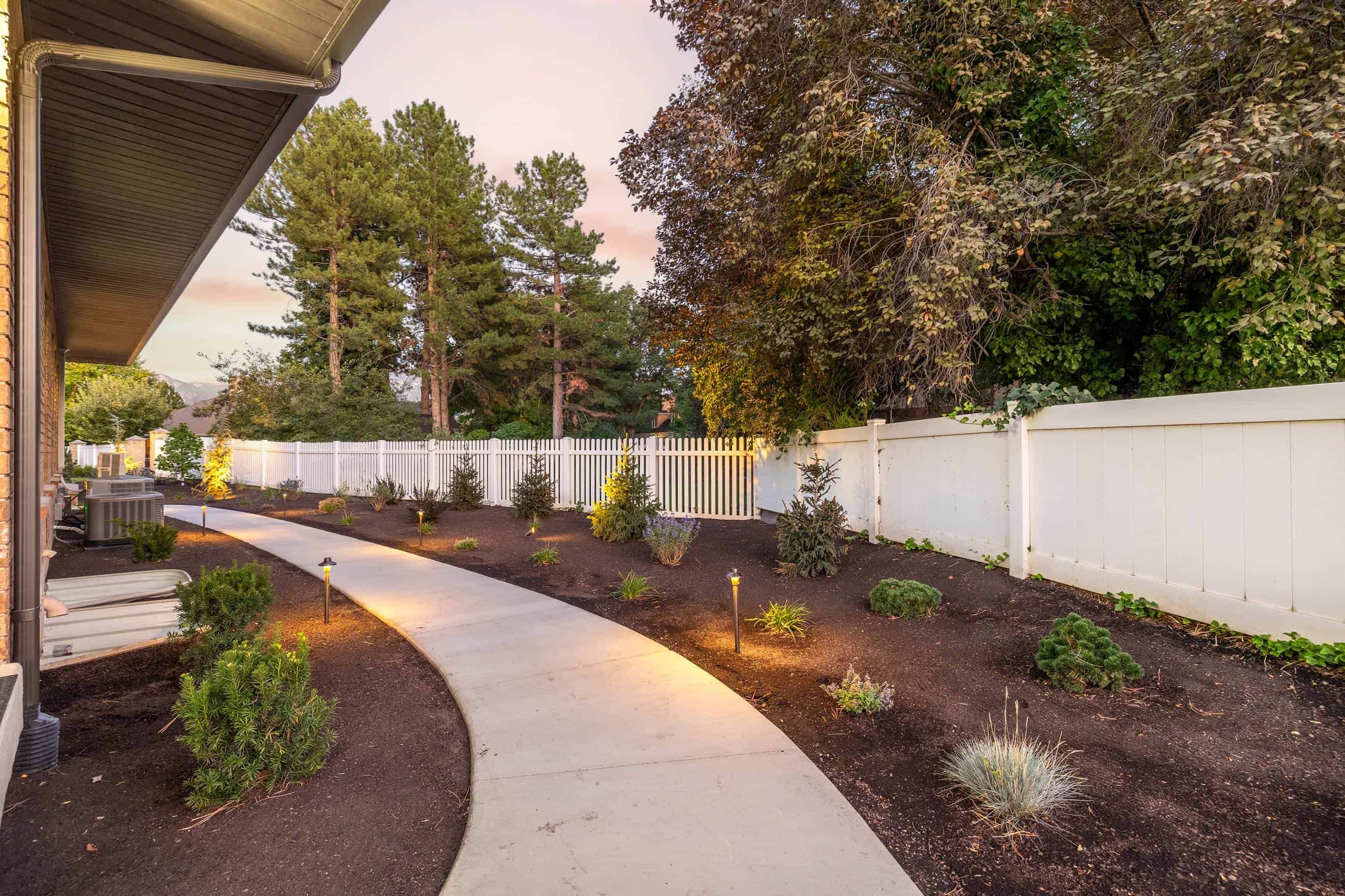 Concrete path with mulch surrounding installed by Pitt Landscape in Murray, Utah.