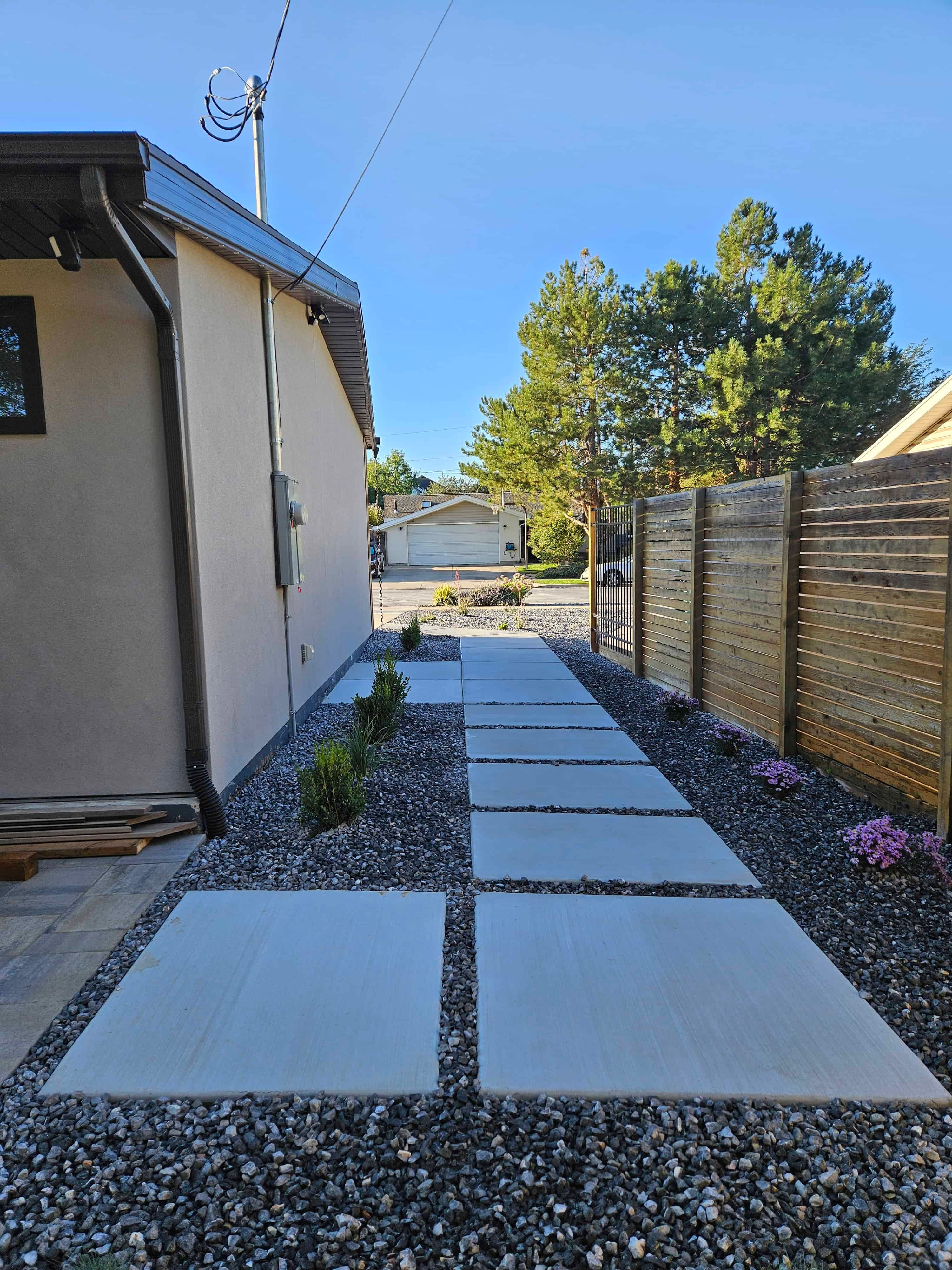 Modern concrete walkway leading to front yard in Murray, Utah landscape project.