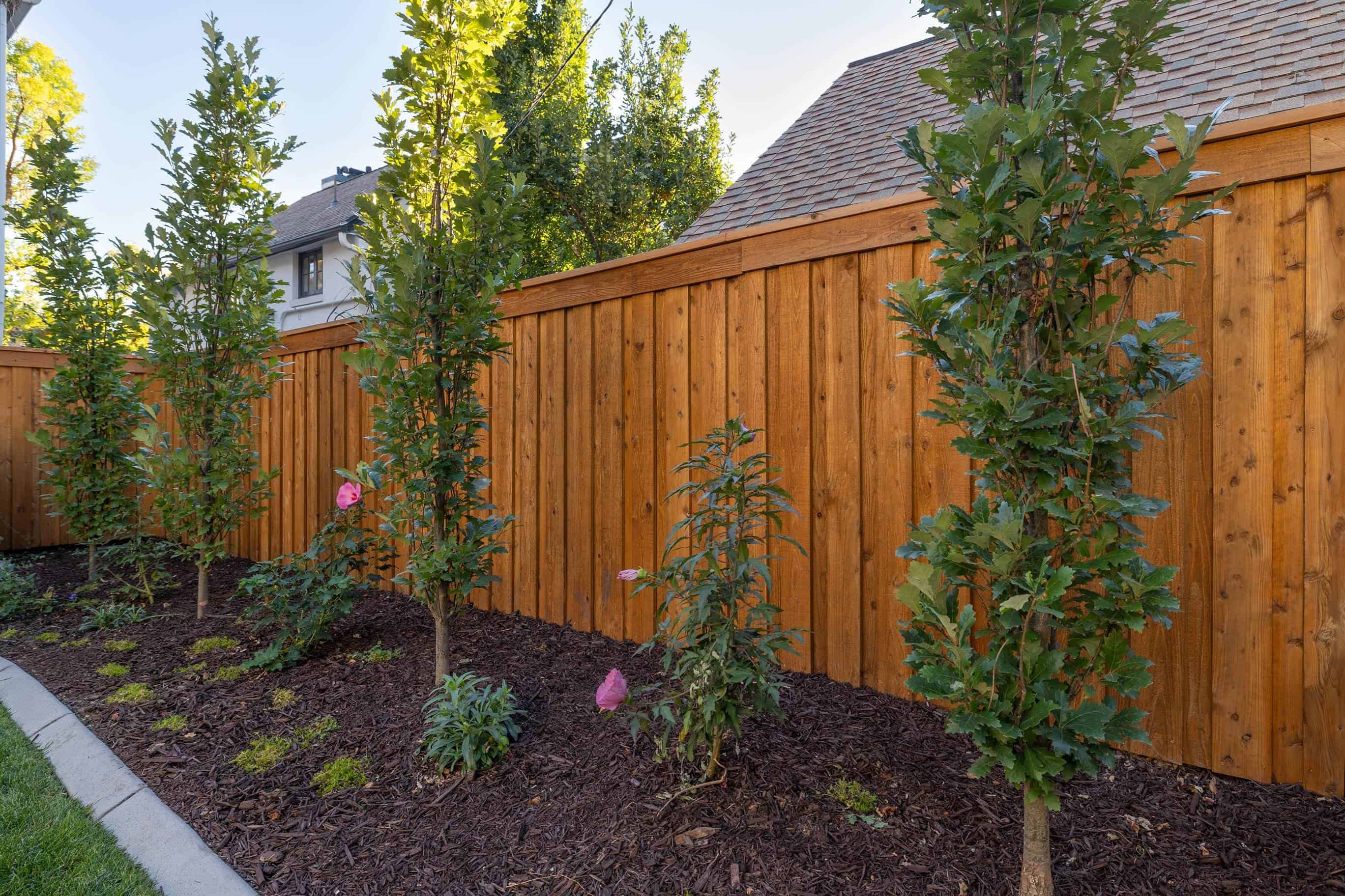 Plant area with custom deck and brown wood fence, blending hardscape and softscape elements in Federal Heights, Utah.