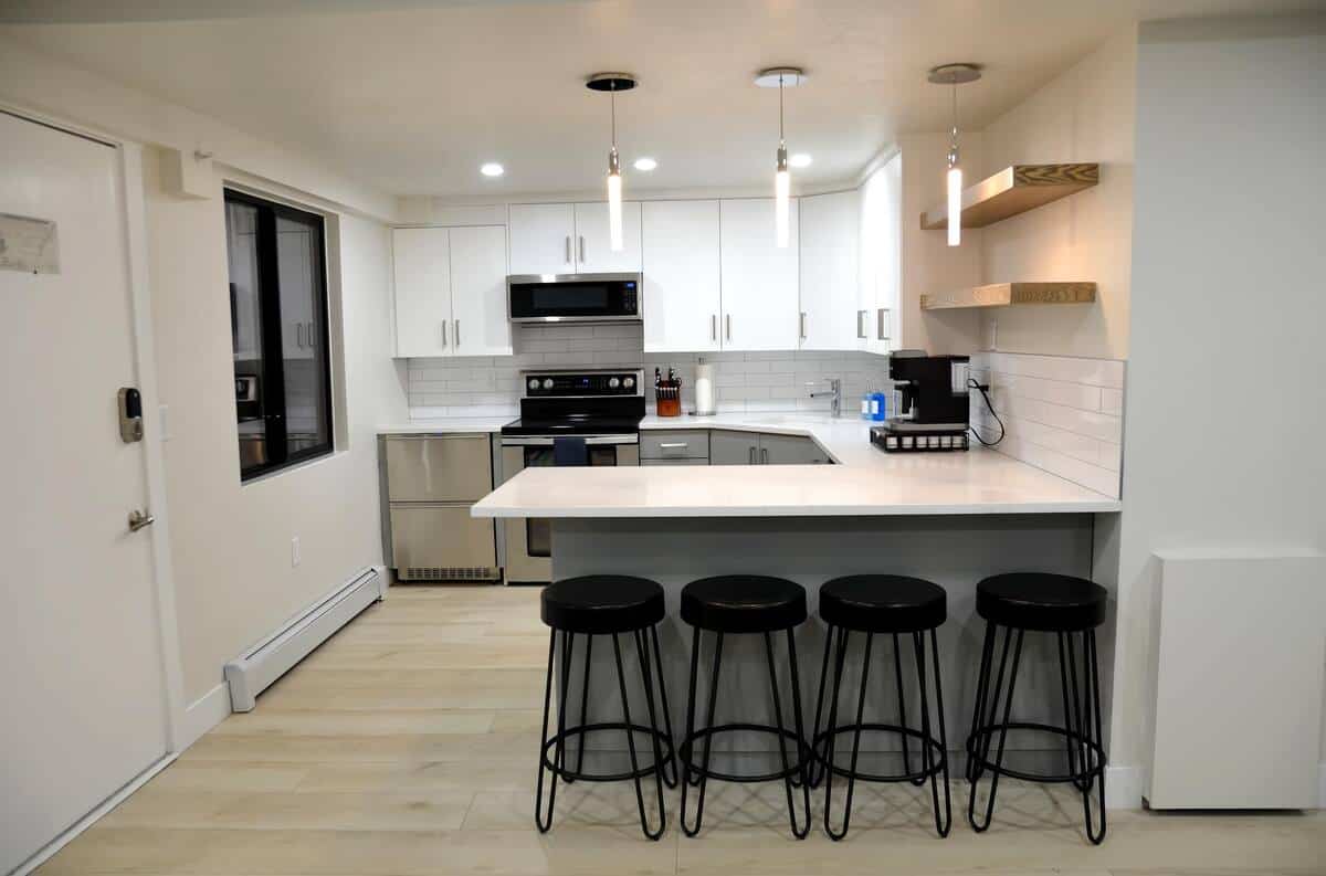 Modern white kitchen remodel with waterfall island and pendant lighting