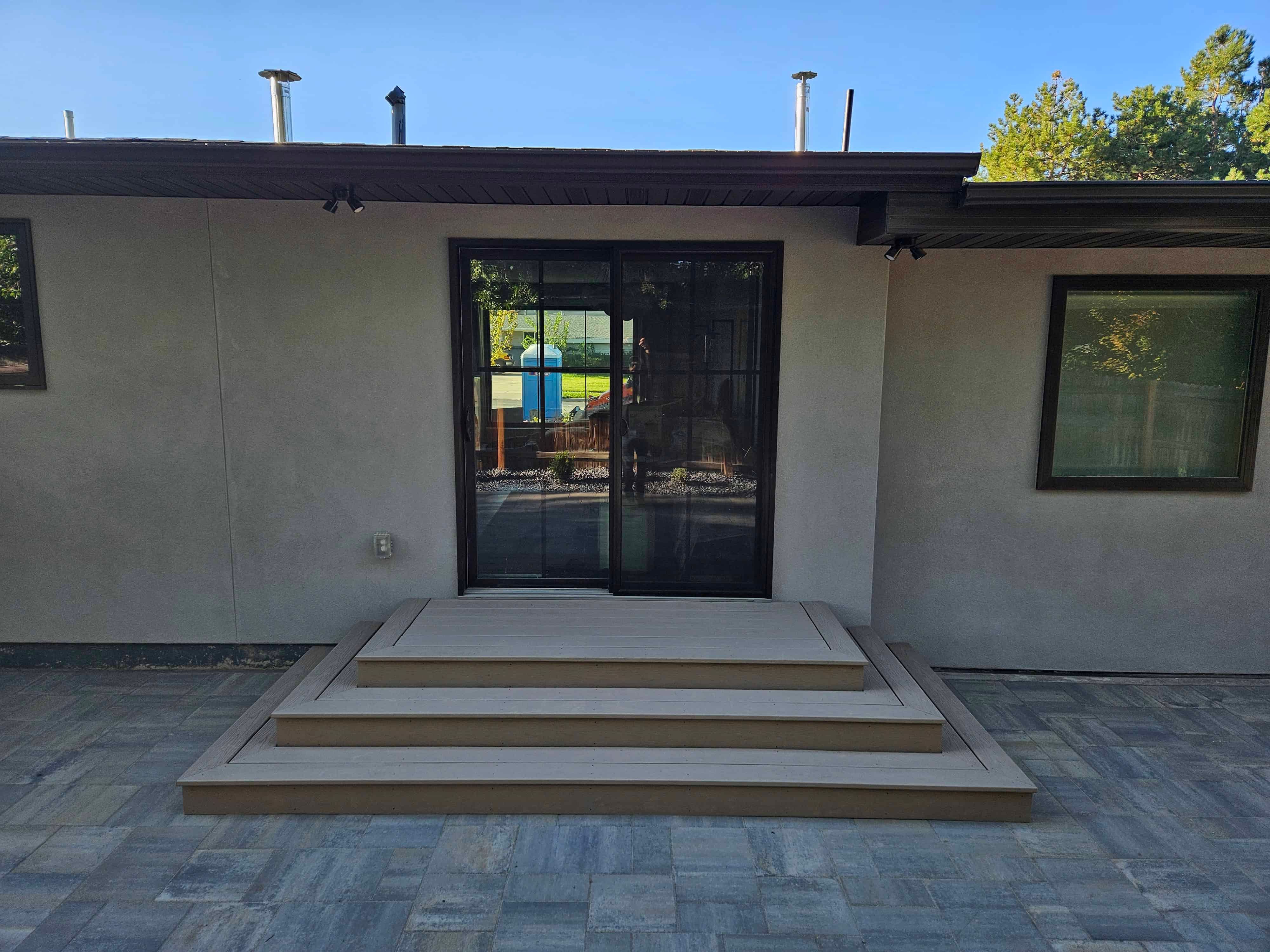 This smaller project involved a deck landing with steps leading to a patio area. Using Trek composite decking, we created a simple yet elegant solution for easy access to the outdoor space while maintaining a cohesive design with the rest of the home.