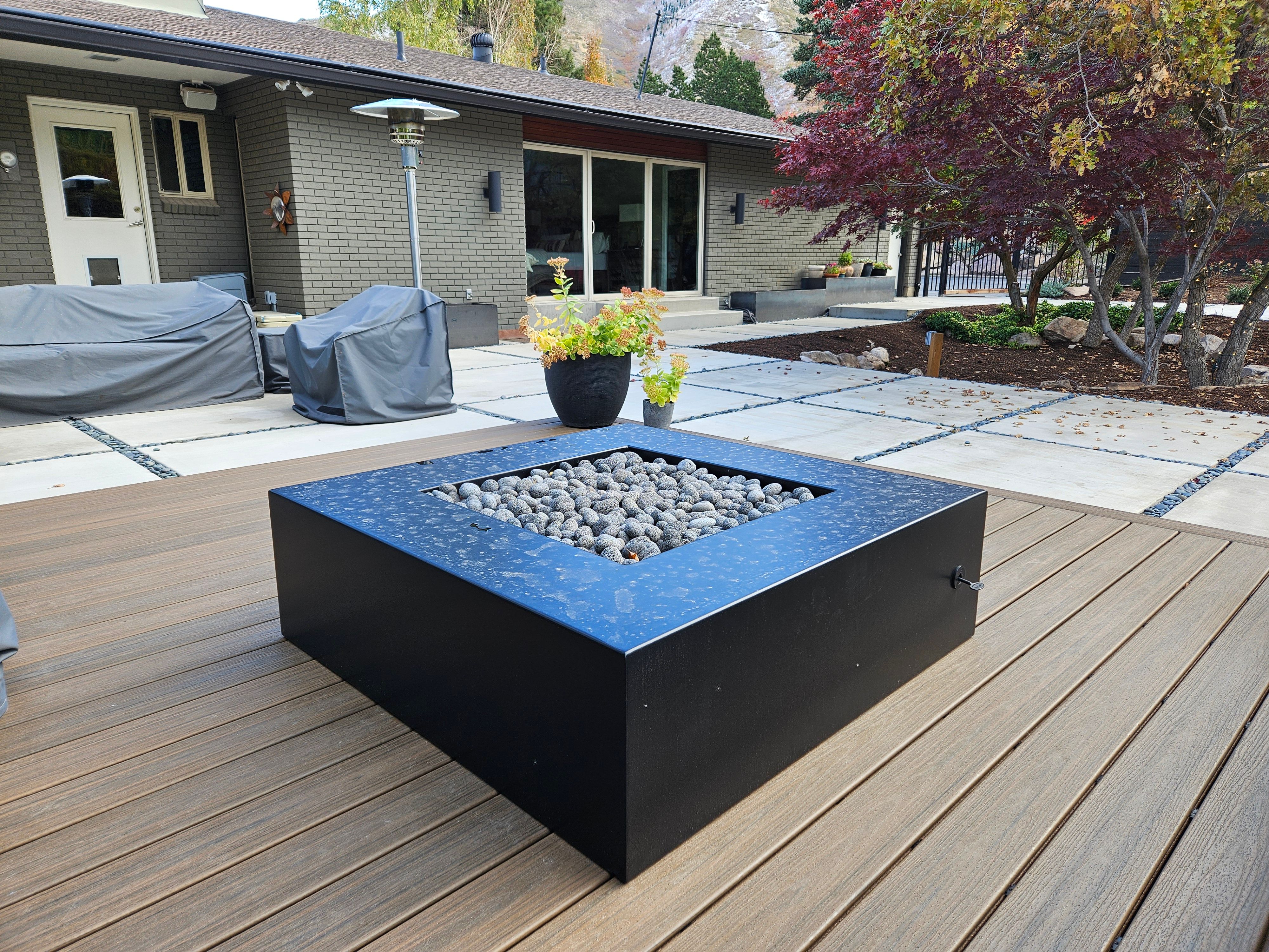 Black steel fire pit installed on Trex deck in Holladay, Utah.