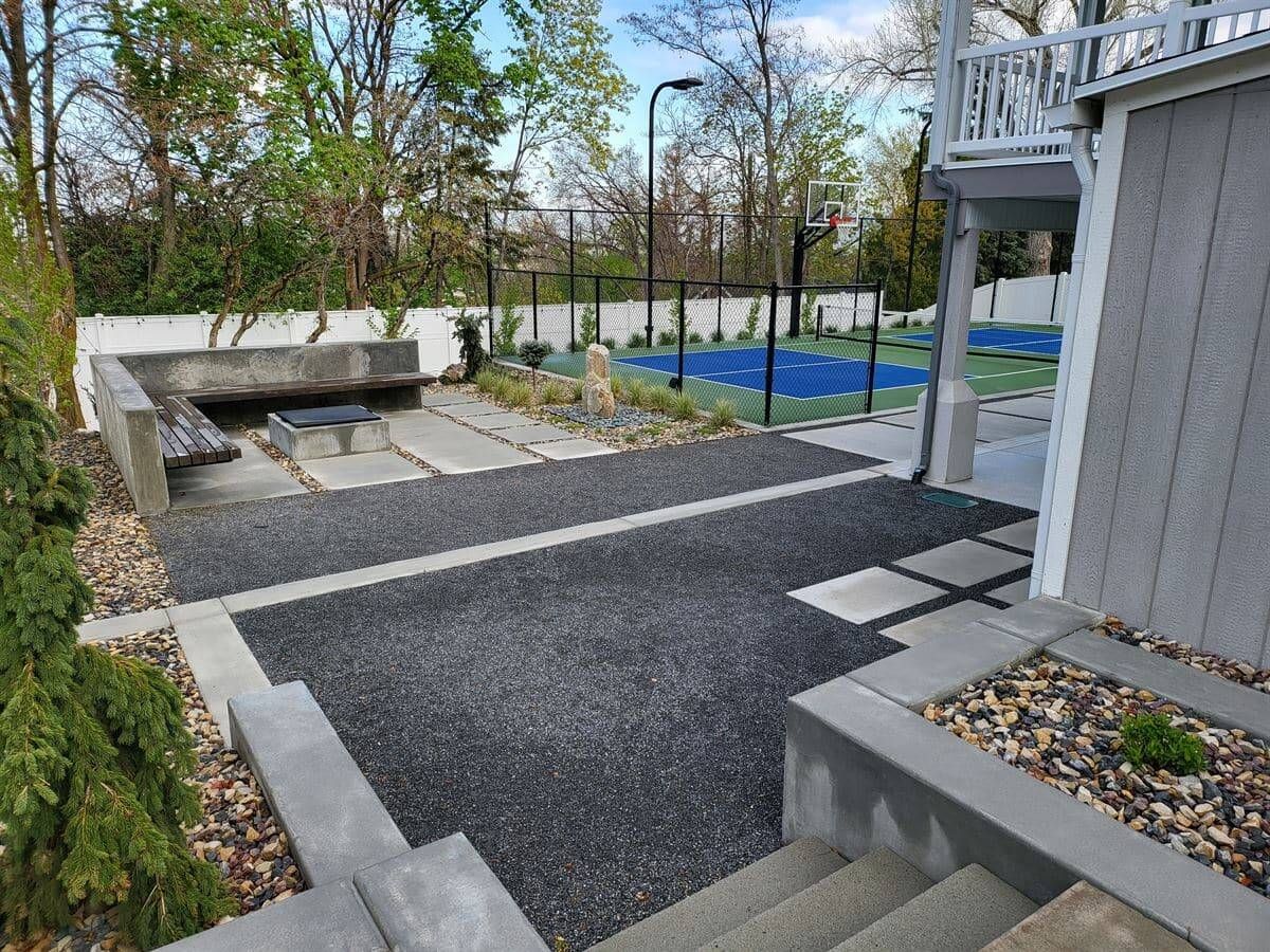 Bountiful backyard fire pit patio with bubbler water feature and modern concrete hardscape.
