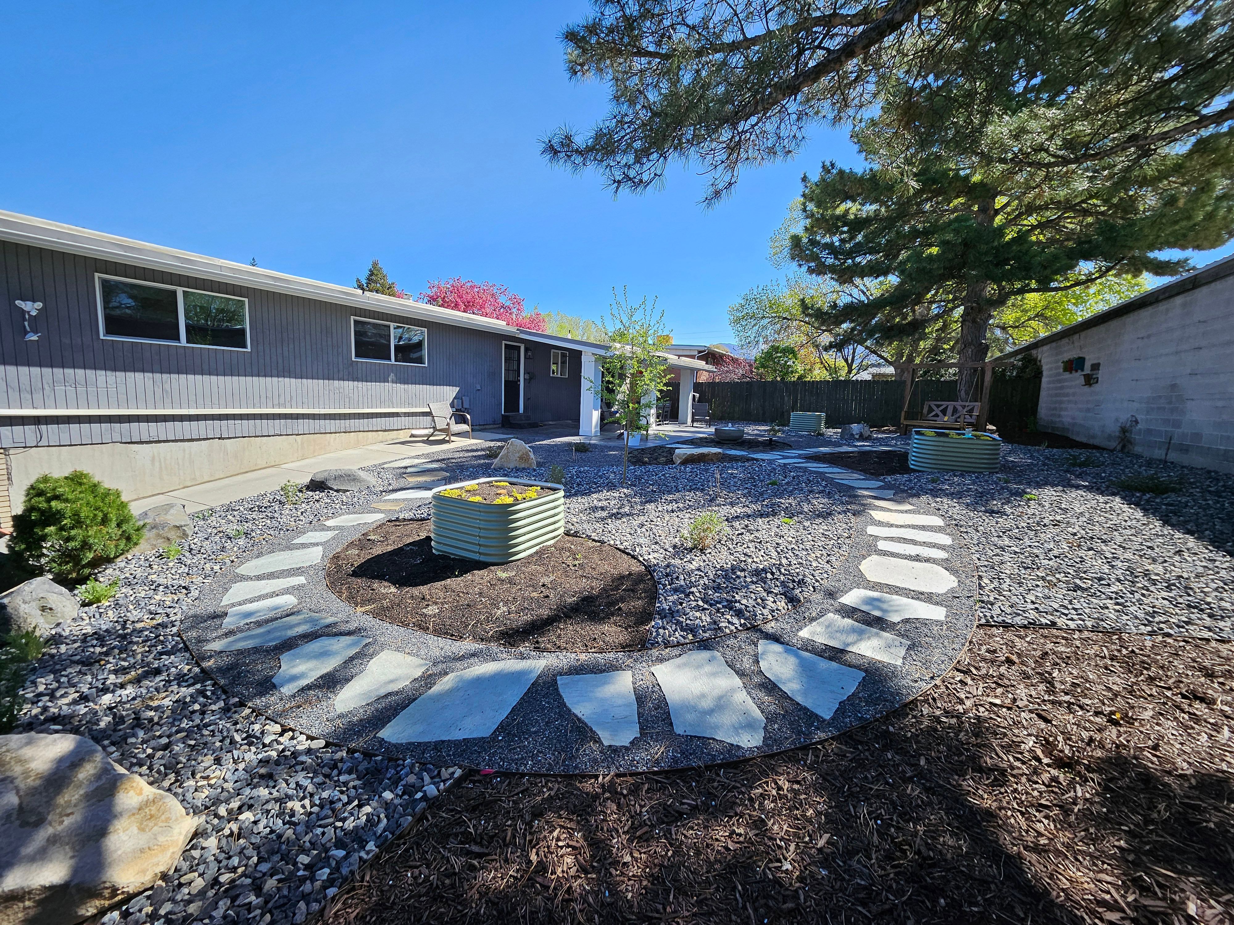 Xeriscape design with native plants, gravel, and stone pathways in Murray, Utah.