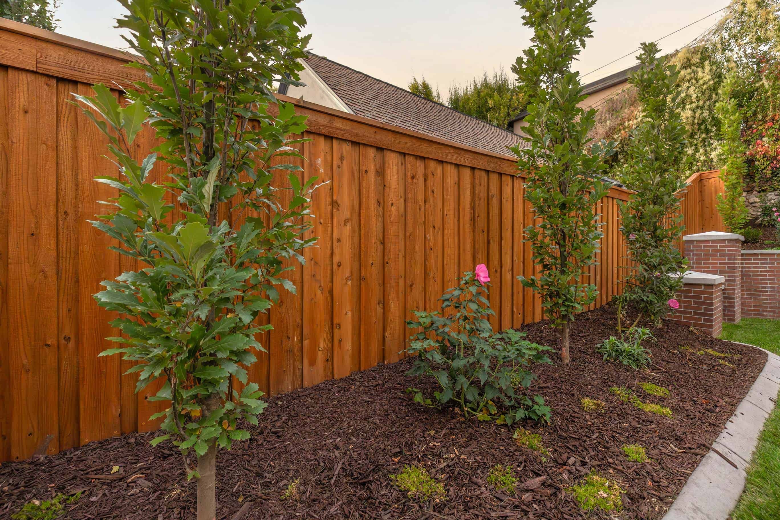 Custom plant area with mulch and brick pillars, providing a low-maintenance landscape solution in Federal Heights, Utah.